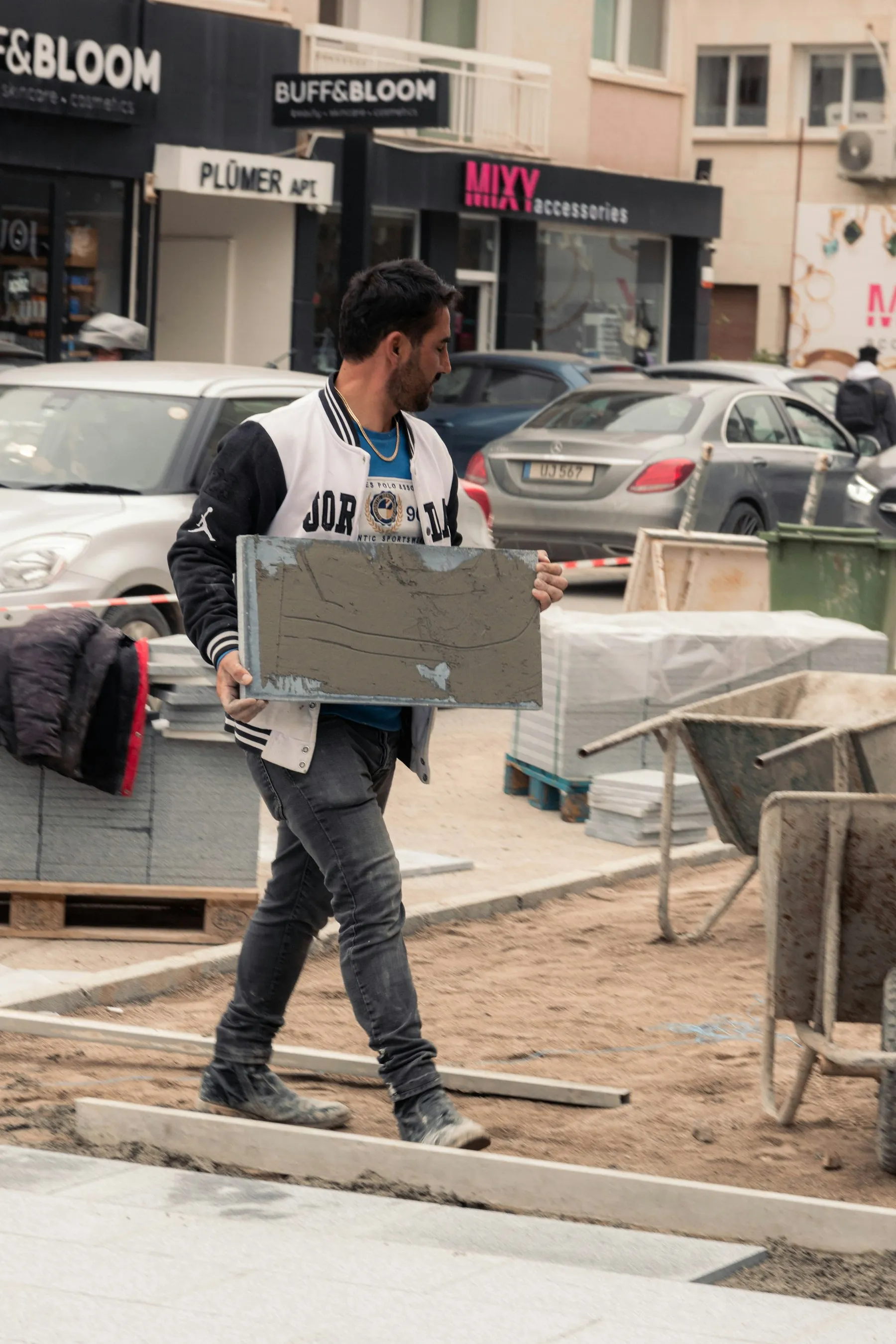 Hombre cargando material de obra en la calle